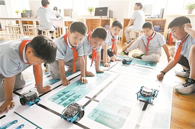 圖為中關(guān)村第三小學(xué)雄安校區(qū)編程社團的學(xué)生檢驗機器人的編程效果。新華社記者 李鑫攝